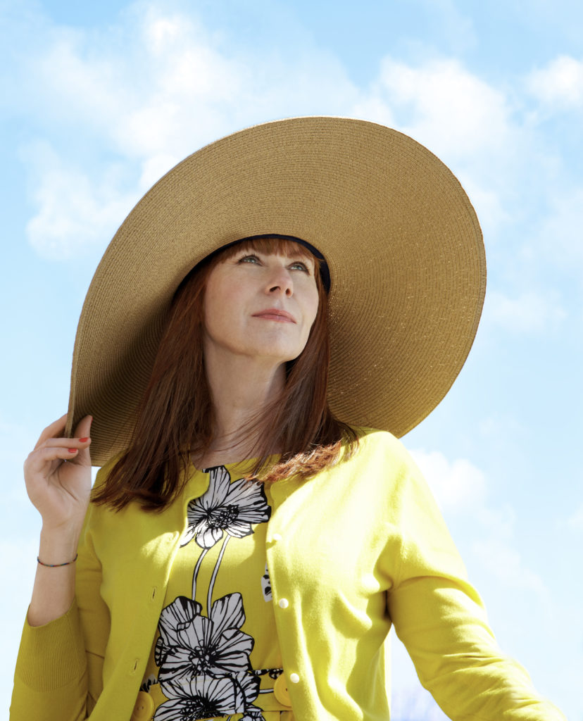 Julie Bain wearing a hat with a yellow dress